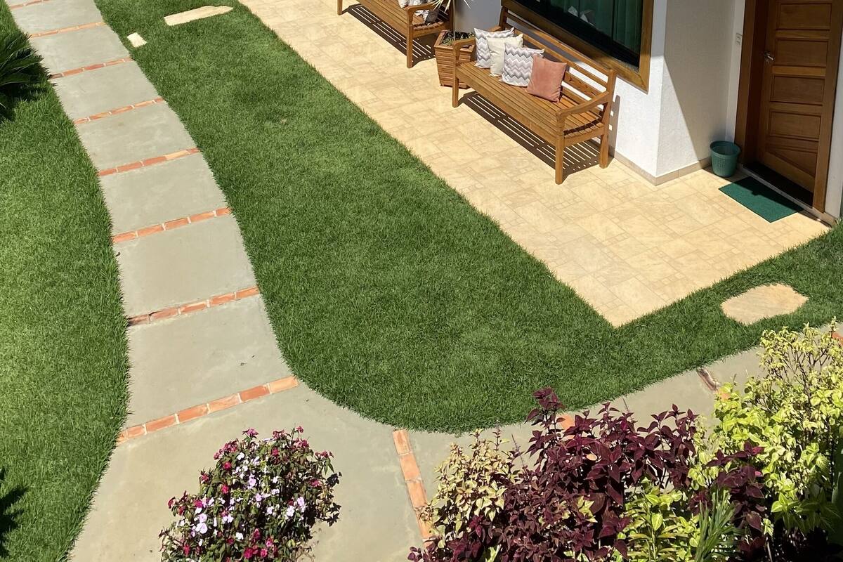 A modern two-story house with a tiled roof, large windows, and a well-maintained lawn.