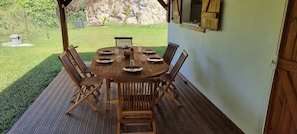 Enjoy casual outdoor dining on the deck with a view of the well-maintained lawn and rocky outcrop.