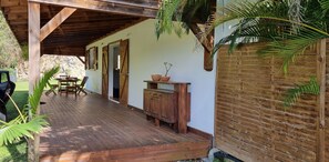 Relax in a serene outdoor space with a wooden deck, bench, and dining table.