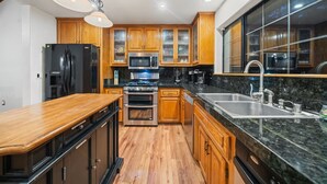 A modern kitchen with wooden cabinets, stainless steel appliances, and a granite countertop. - Family Retreat: Near Town, Hot Tub, AC, (Idyllwild)