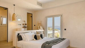 A modern bedroom with a large bed, a bedside table, a mirror, and a view of the outdoors. - Ventus di Milo (Milos)