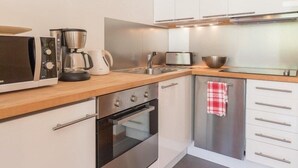 A modern kitchen with stainless steel appliances, a coffee maker, a toaster, and a kettle. - 4th floor, view ski slopes, balcony, parking, 28m², Serre Chevalier (SERRE CHEVALIER)