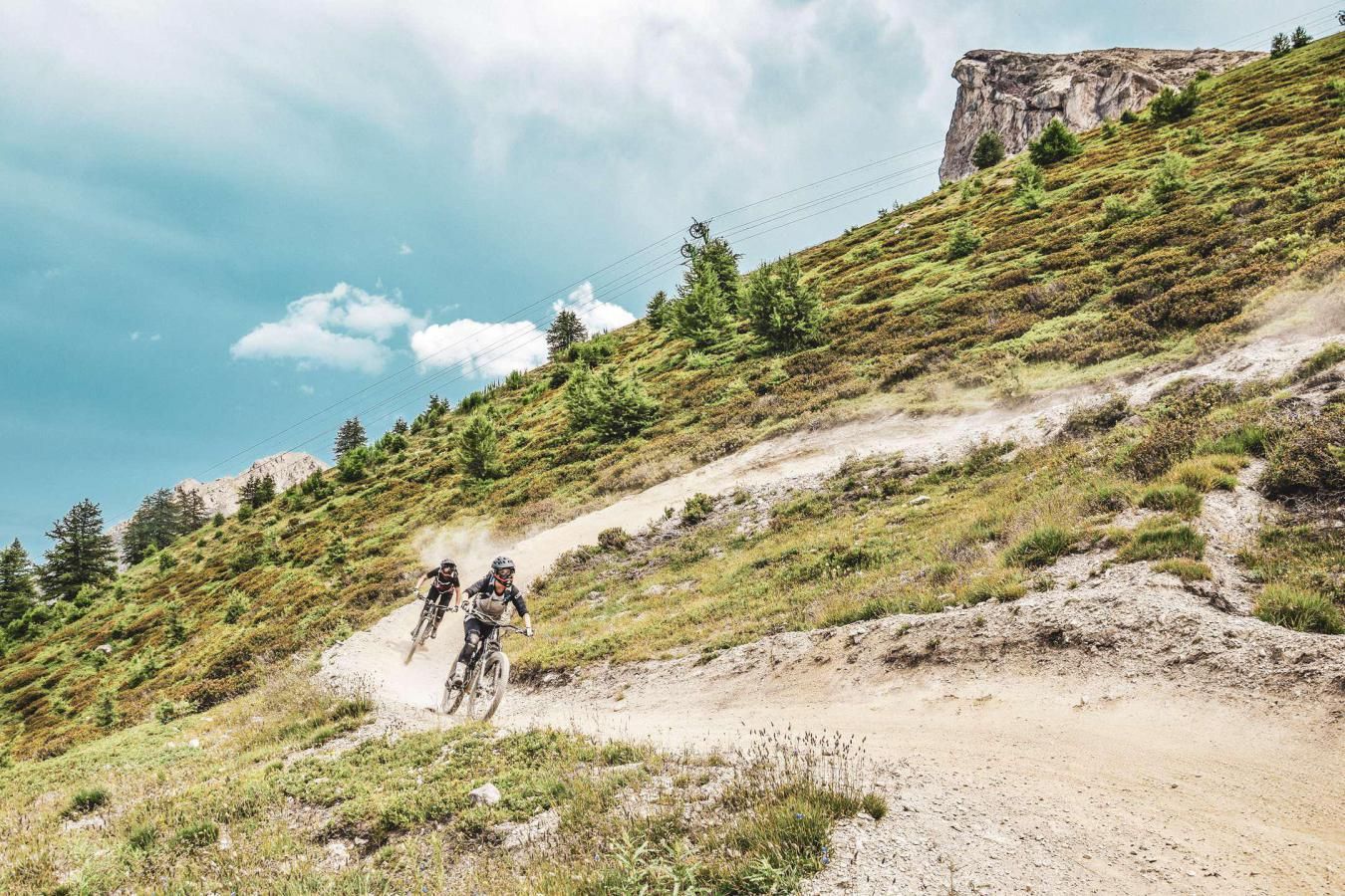 Un sentiero sterrato su un pendio con due ciclisti.