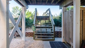 Une entrée privative, avec un portail en bois, un chemin de gravier et un espace abrité doté d’une grille métallique.