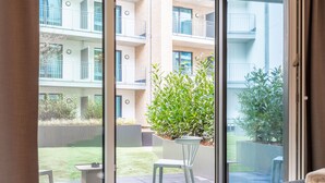 A bedroom with a large sliding glass door leading to an outdoor patio area. - Limehome Münster Von-Steuben-Str. (Münster)