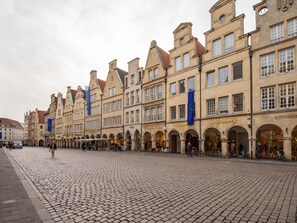 A cobblestone square with historic buildings, including a jewelry store and a cafe. - Limehome Münster Von-Steuben-Str. (Münster)