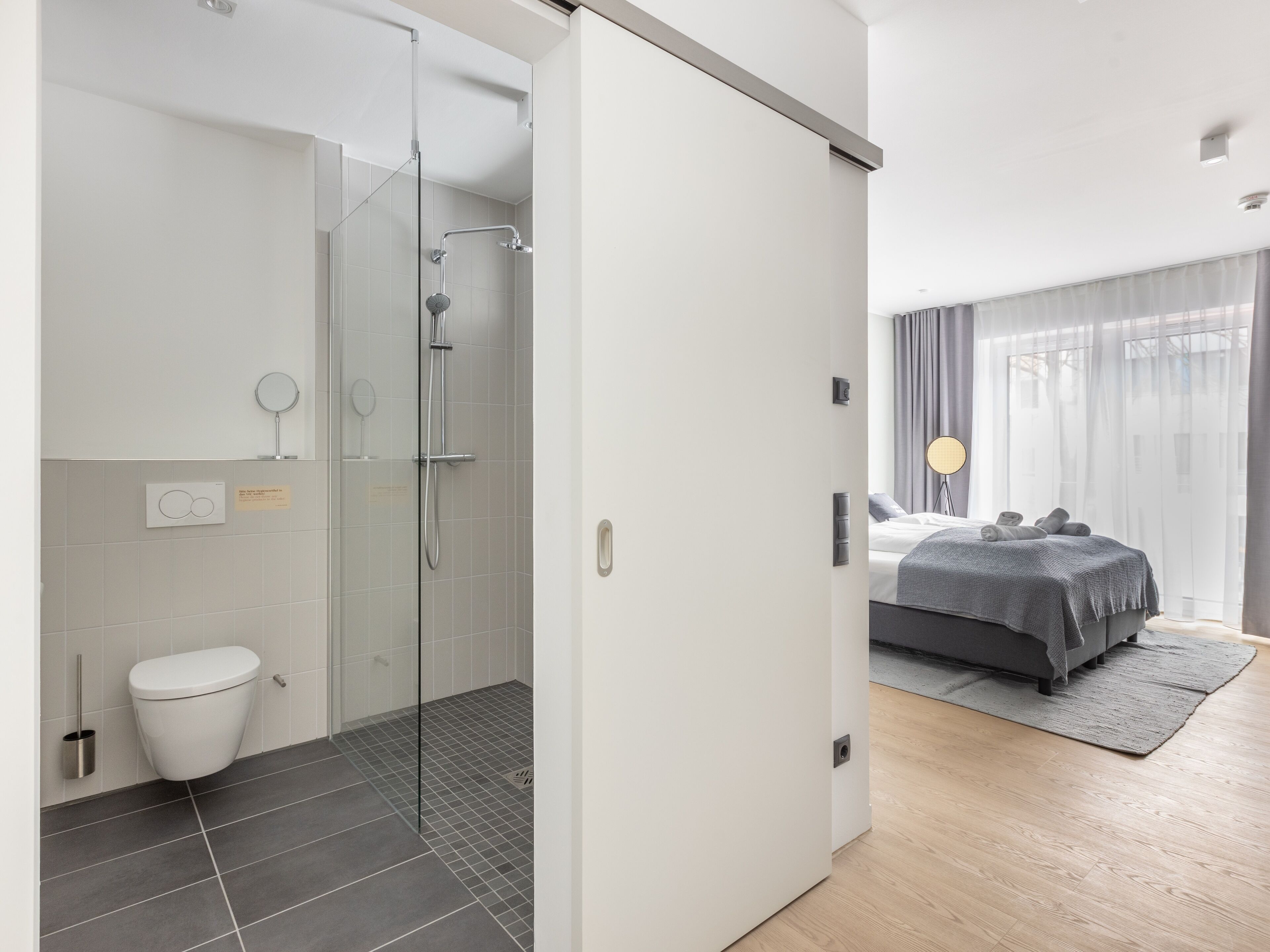 Un bagno moderno con box doccia in vetro, un water e un lavabo.