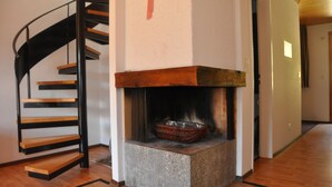 Un escalier en colimaçon avec une cheminée en contrebas.