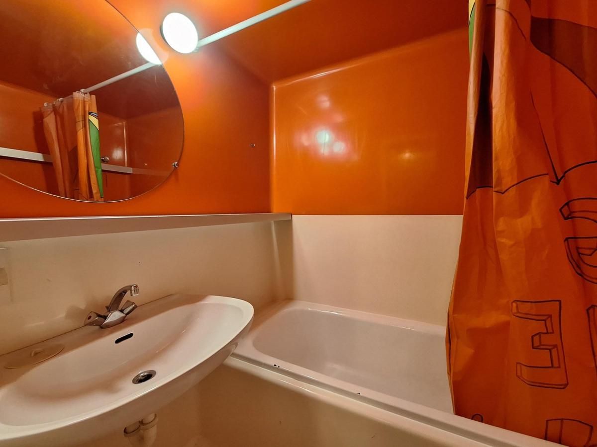 Ein Badezimmer mit einem weißen Waschbecken, einer Badewanne und einem Spiegel.