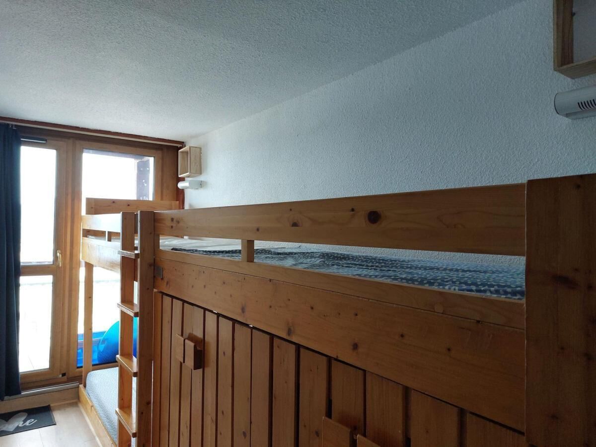 Ein Holzbett mit Etagen und Blick auf das Meer durch ein Fenster.