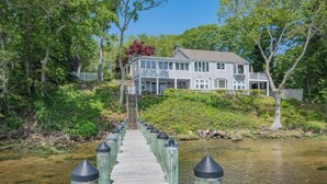 A wooden pier leading to a house by a river. - Private Deep Water Dock, heated pool and hot tub RPMS005 (Marstons Mills)