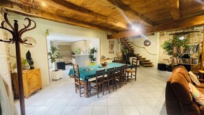 Un intérieur rustique comprenant un coin repas, un escalier en bois et un espace salon confortable.
