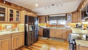 A spacious kitchen with wooden cabinets, stainless steel appliances, and a granite countertop.