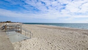 A beach with a concrete walkway leading to a staircase.
