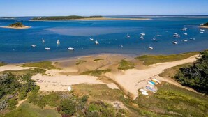 Luftaufnahme einer Küstenregion mit Booten, Sandstränden und einer kleinen Insel.