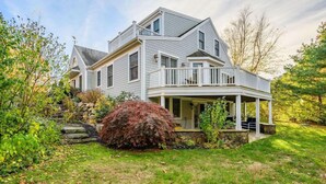 A two-story house with a porch and a stone staircase leading to the entrance. - Large Chatham Rental w/ 5 Bedrooms w/ 5 Private Bathrooms RPAM007 (Chatham)