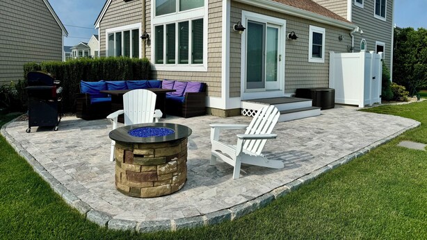 A house with a patio area featuring a stone fire pit, outdoor seating, and a white fence. - Boater's Paradise with Beaches Nearby! RPAM010 (South Yarmouth)