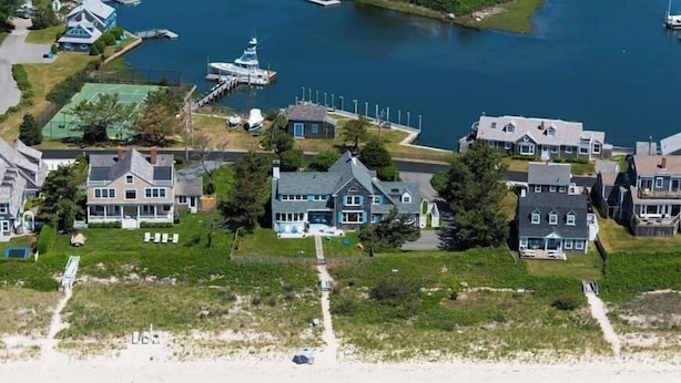 An aerial view of a coastal residential area with houses, a dock, and a beach. - Craigville Long Beach Beachfront rental home. On private beach. RPMS029 (Centerville)