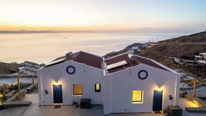 Il s’agit d’un bâtiment situé sur la côte, composé de deux structures principales, chacune étant dotée d’une fenêtre circulaire et d’une porte. Le bâtiment est situé sur une colline, d’où l’on a une vue sur une mer calme.