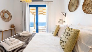 Une chambre d’hôtel avec un lit, des serviettes, une vue sur la mer et un balcon.