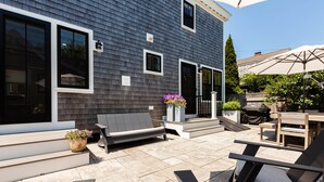 A patio with outdoor furniture, a wooden table, and a large umbrella. - Exquisite 3 bedroom home in a great location! RPSH005 (Provincetown)