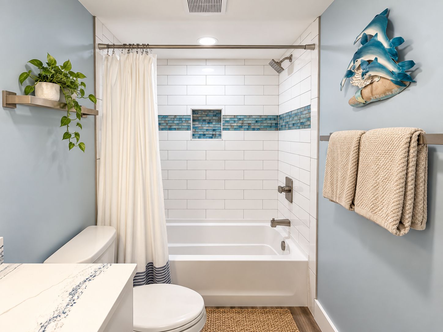 A bathroom with a bathtub, toilet, and shower curtain.