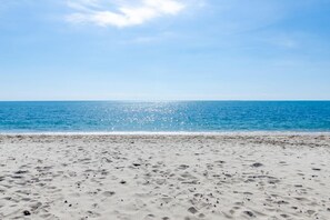Ein Strand mit blauem Himmel und ruhiger See.