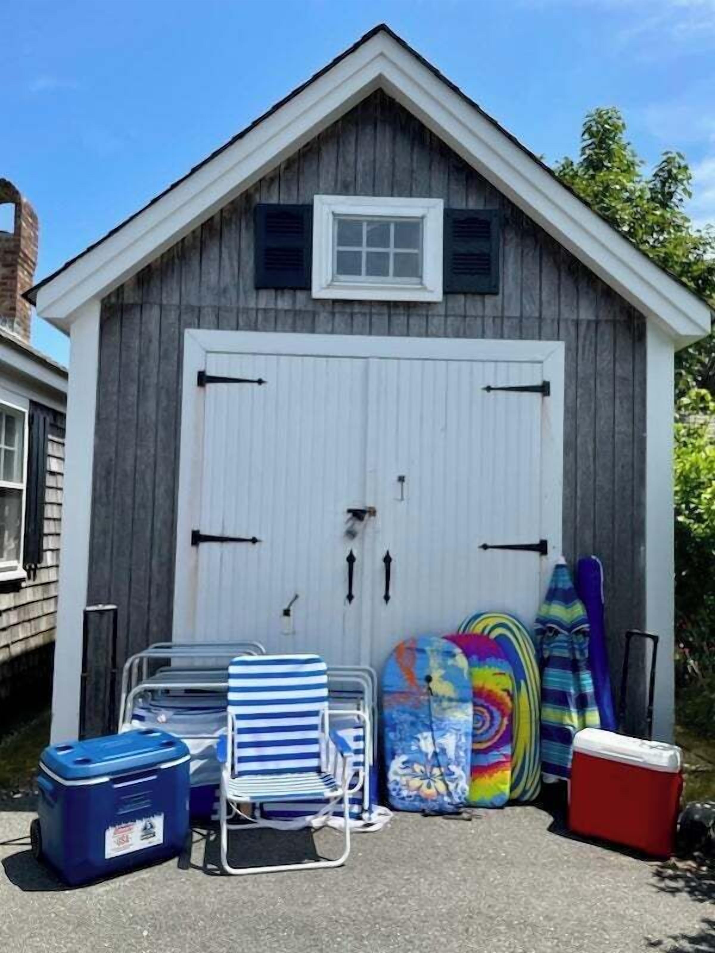 Un garage avec une porte blanche, deux fenêtres et une petite fenêtre au-dessus de la porte.