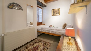A bedroom with a bed, a bedside lamp, a window, a radiator, and a mirror. - Ca' Pinina (Lugano)