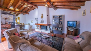 A cozy living room with wooden beams, a fireplace, and a television. - Ca' Pinina (Lugano)