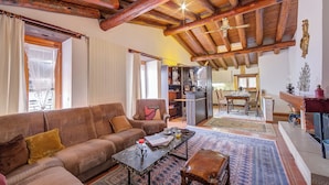 A cozy living room with a wooden ceiling, a sofa, a coffee table, and a patterned rug. - Ca' Pinina (Lugano)