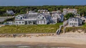 Una zona residencial costera con varias casas, una playa y cielo despejado.
