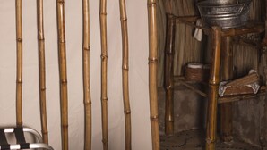 A bamboo wall with a metal bucket on a wooden stand. - casademarthayjaimealjuntoalrioveracruz (Veracruz)