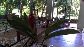 A spacious indoor area with large windows, a tiled floor, and a variety of furniture including a table and chairs. - casademarthayjaimealjuntoalrioveracruz (Veracruz)