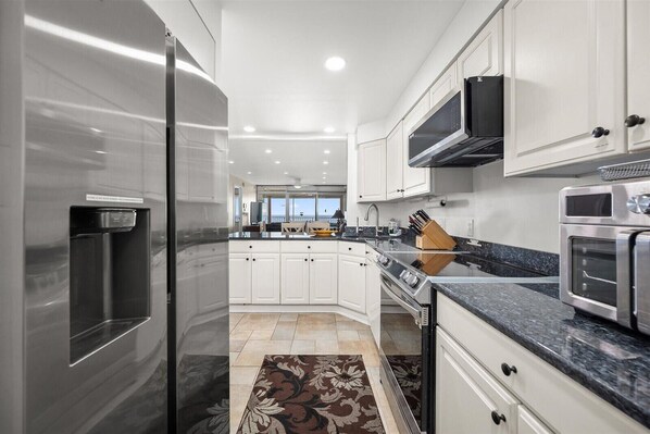 Enjoy cooking in this well-lit kitchen with a gas stove, microwave, and refrigerator.