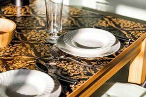 A dining table with a patterned tablecloth, a glass, and cutlery. - Hardwood Home (London)