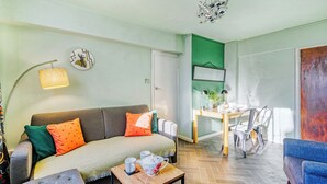 Un salon comprenant un canapé, une table basse et un coin repas avec une table et des chaises.