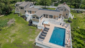 A large two-story house with a swimming pool, a covered deck, and a staircase leading to the upper floor. - Elevate Your Cape Stay: Chatham Luxury with Pool & Beach RPAM026 (Chatham)