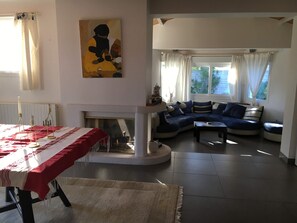 A living room with a sofa set, a fireplace, and a painting on the wall.