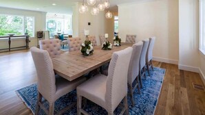 Comedor con una mesa de madera, seis sillas tapizadas y un candelabro.