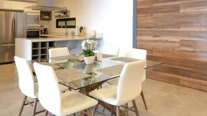 A modern kitchen with a glass dining table surrounded by white chairs. - 5 Blocks to Beach | Icono Oceanview Pool & Hot Tub (Playa del Carmen)