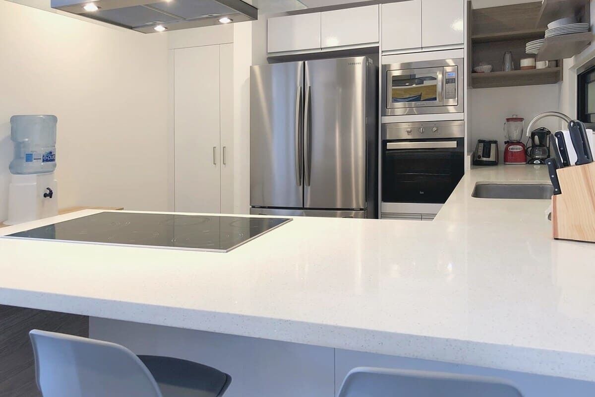 A modern kitchen with stainless steel appliances, a water dispenser, and a built-in island.