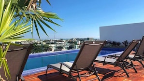 A rooftop pool area with lounge chairs and a view of the city. - 5 Blocks to Beach | Icono Oceanview Pool & Hot Tub (Playa del Carmen)