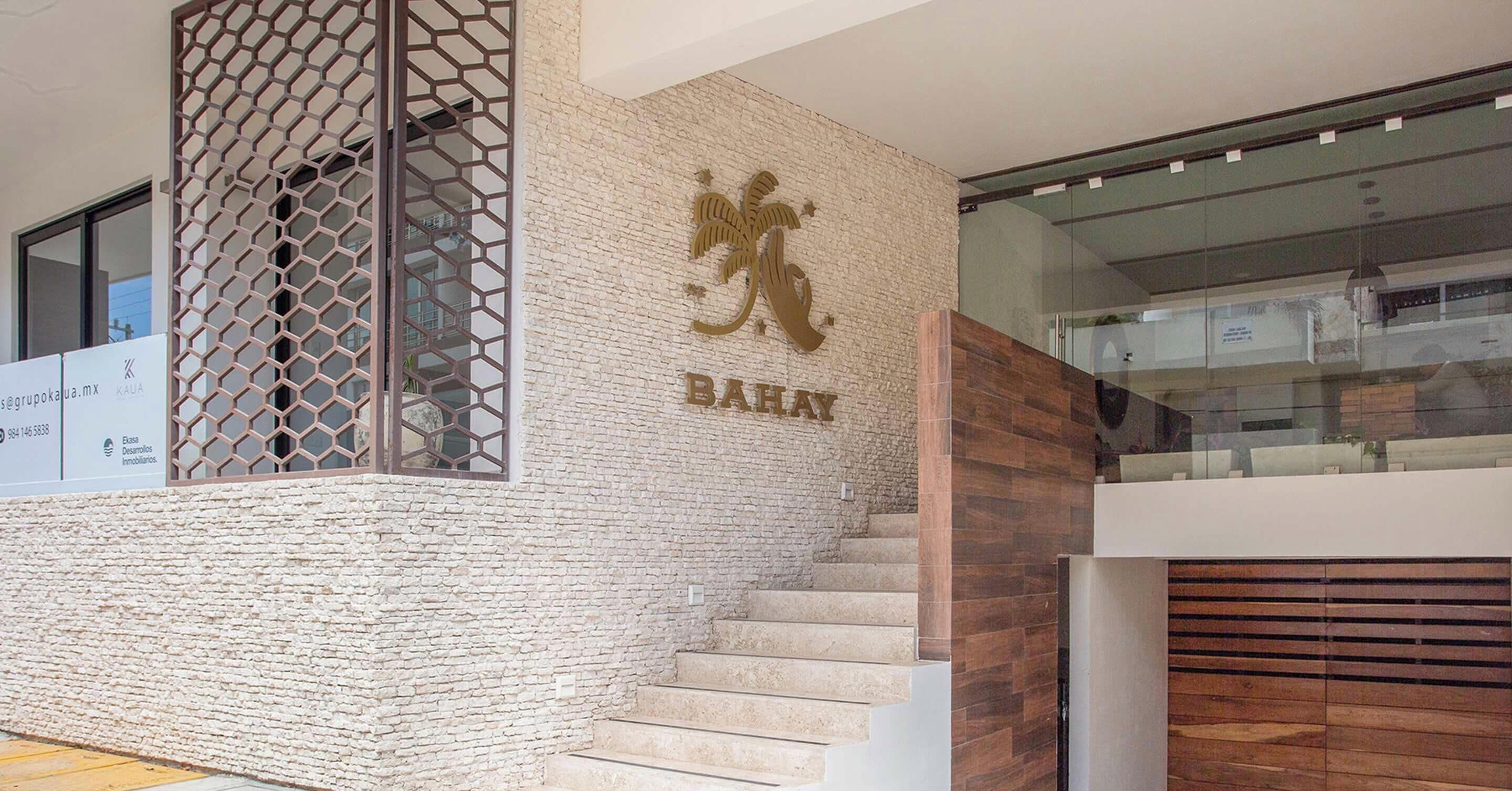 A staircase leading to a room with a textured wall and a logo.