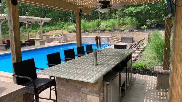 An outdoor bar area with a pool, seating, and a pergola. - Resort like Backyard-Pool, Putting green, Outside Kitchen, Fire Pit, Bar, Lounge (Hampton Bays)