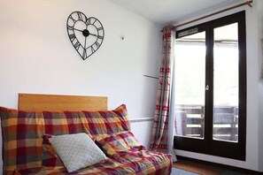 A bedroom with a bed, a heart-shaped clock on the wall, and a window with curtains. - 50m from ski slopes, 3rd floor, balcony, 26m², Les Orres (Les Orres)