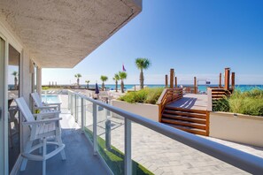 Ein Balkon mit Pool, Holzterrasse und Blick auf den Strand.