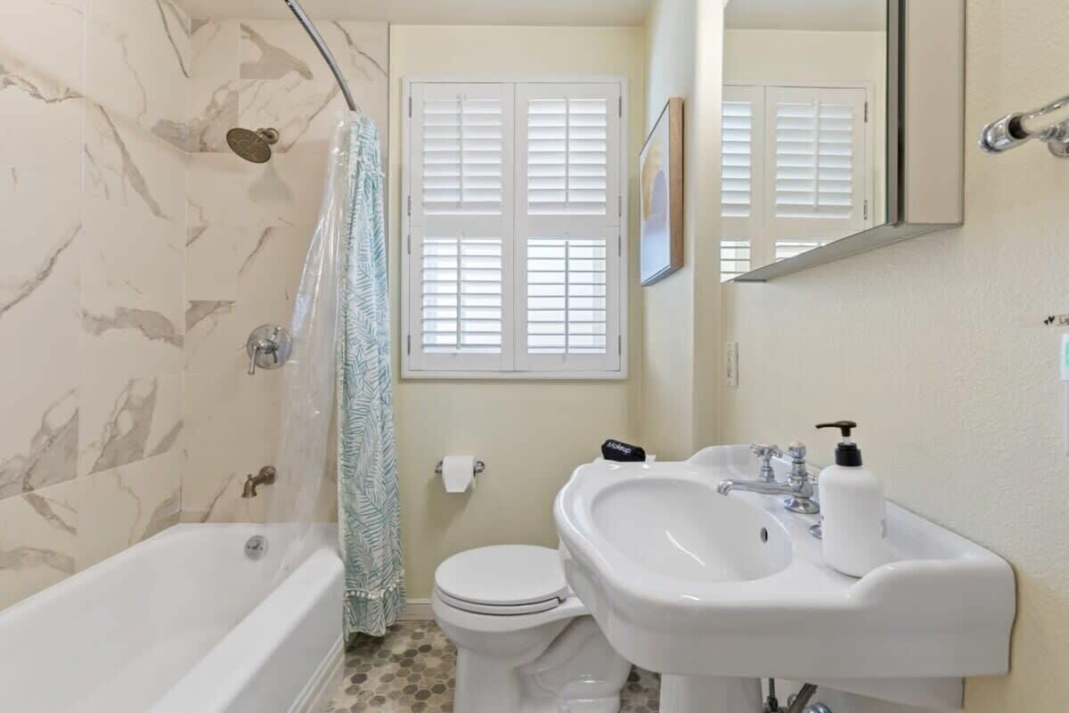 A bathroom with a bathtub, toilet, and sink.