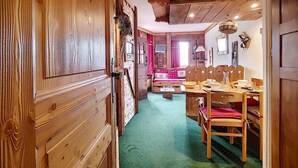 Een houten interieur met een eethoek, een bank en een televisie.