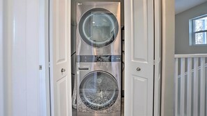 Une buanderie équipée de deux machines à laver à chargement frontal superposées.